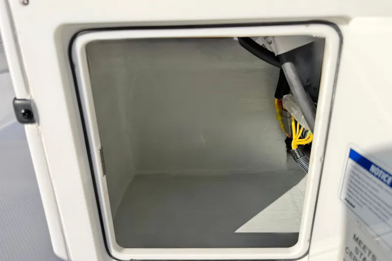 Slide: The Image of Open storage compartment on a 2021 Novurania Deluxe 335 boat, showing interior wiring. - 16