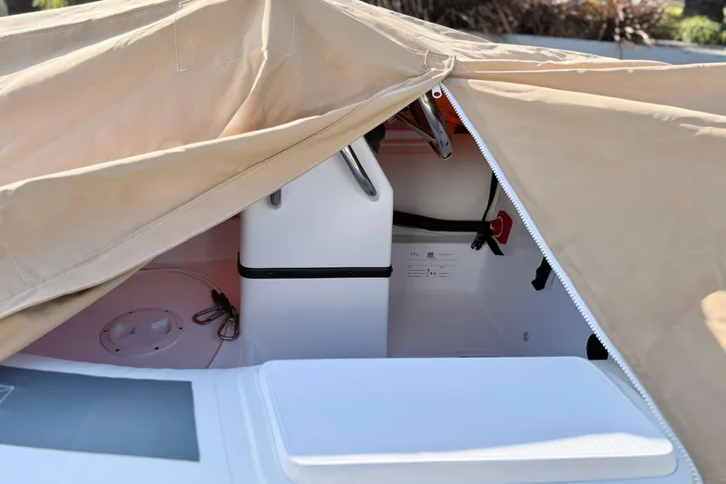 Slide: The Image of 2021 Novurania Deluxe 335 boat interior partially covered by a beige tarp. - 25