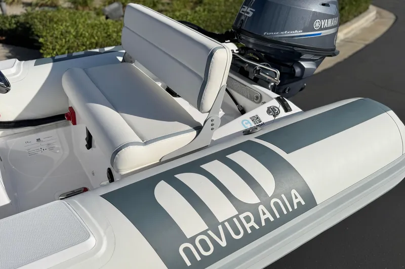 The Image of 2021 Novurania Deluxe 335 boat with Yamaha engine, featuring sleek white seating and branding. - 6