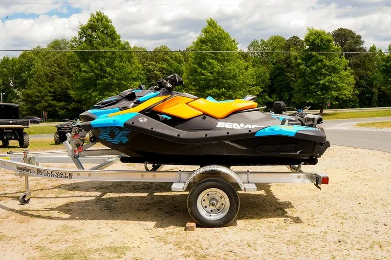 The Image of 2026 Sea-Doo Spark Trixx on trailer, vibrant colors, parked outdoors. - 1