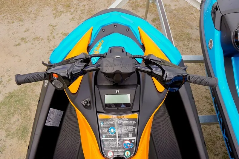 Slide: The Image of 2026 Sea-Doo Spark Trixx handlebars and dashboard, vibrant orange and blue design. - 11