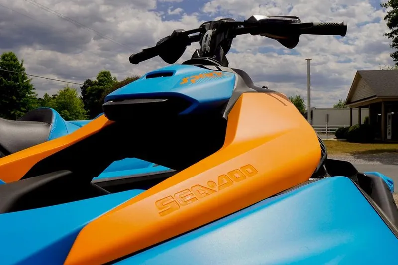 Slide: The Image of 2026 Sea-Doo Spark Trixx jet ski in vibrant blue and orange under cloudy sky. - 3