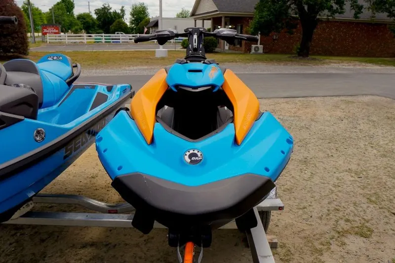 Slide: The Image of 2026 Sea-Doo Spark Trixx for 1, blue and orange, parked on a trailer. - 7