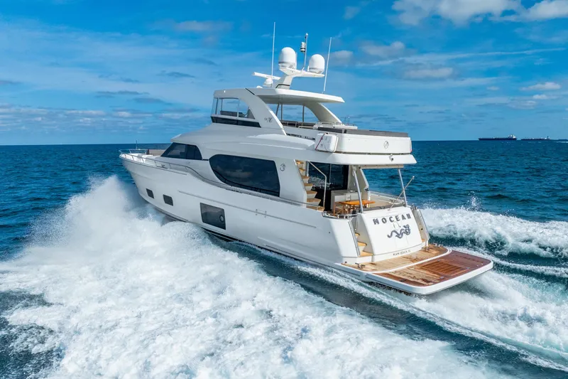Slide: The Image of 2021 Ocean Alexander 70E Motoryacht cruising on open sea under clear blue sky. - 11