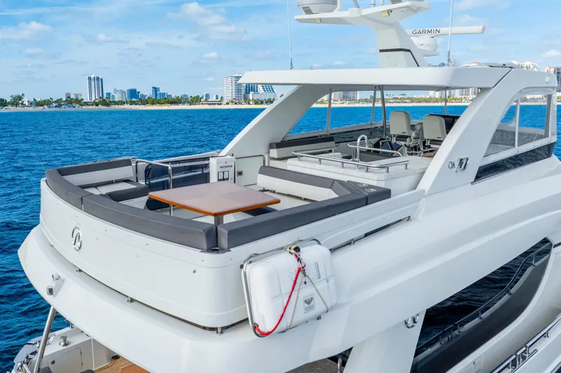 Slide: The Image of 2021 Ocean Alexander 70E Motoryacht with spacious deck, cruising near a city skyline. - 14