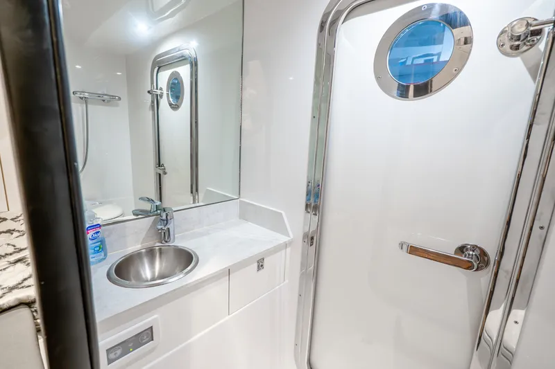 Slide: The Image of Luxurious bathroom in 2021 Ocean Alexander 70E Motoryacht with modern fixtures and porthole. - 60