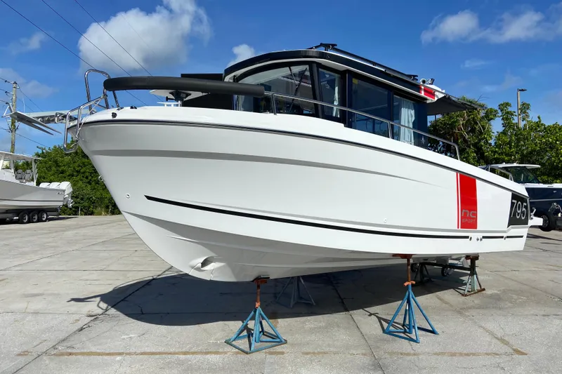 The Image of 2026 Jeanneau NC Sport 795 Series 2 boat on stands, displayed outdoors under blue sky. - 0