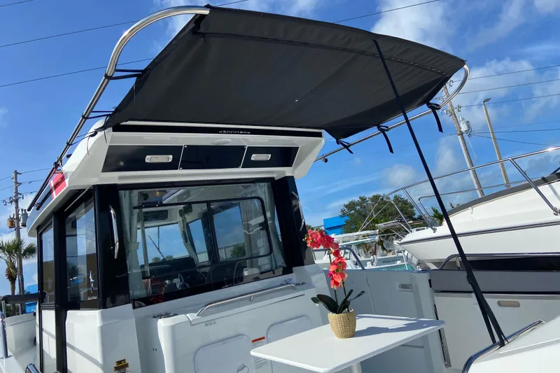 Slide: The Image of 2026 Jeanneau NC Sport 795 Series 2 boat with canopy and table, docked under blue sky. - 3