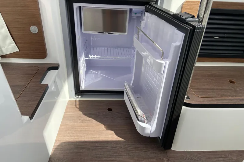 Slide: The Image of Open refrigerator on Jeanneau NC Sport 795 Series 2 boat, showcasing interior storage space. - 35