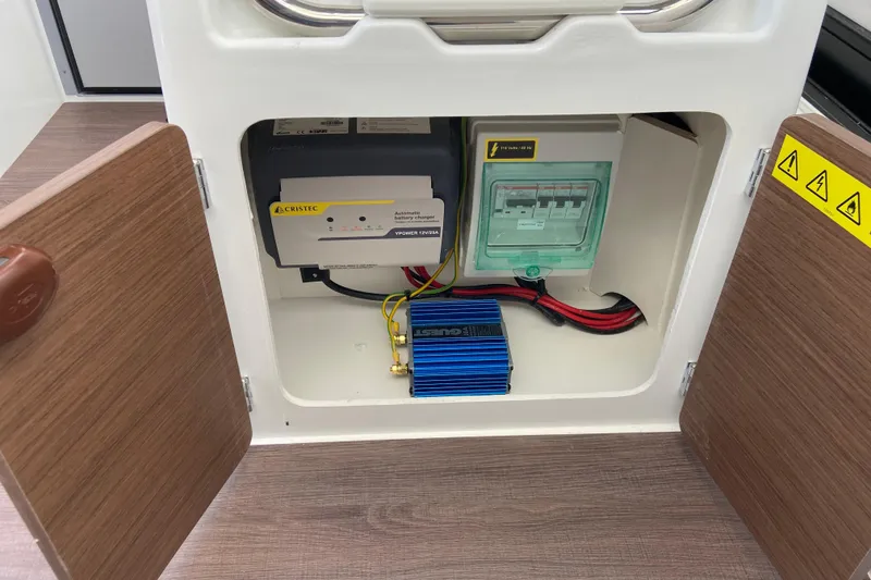Slide: The Image of Electrical compartment of 2026 Jeanneau NC Sport 795 Series 2 boat, featuring battery charger and wiring. - 46