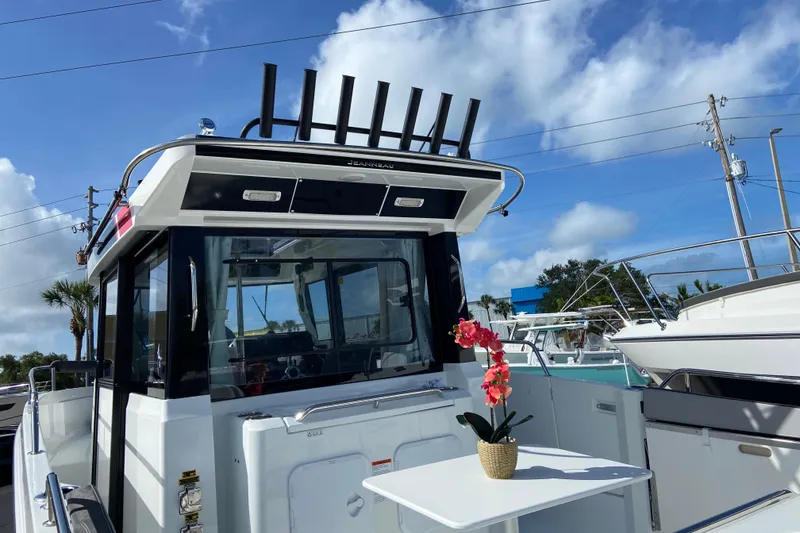 Slide: The Image of 2026 Jeanneau NC Sport 795 Series 2 boat with table and flower, under blue sky. - 5