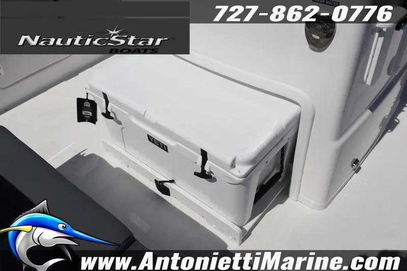 Slide: The Image of NauticStar 292 Legacy boat deck featuring a YETI cooler, contact info, and website details. - 14