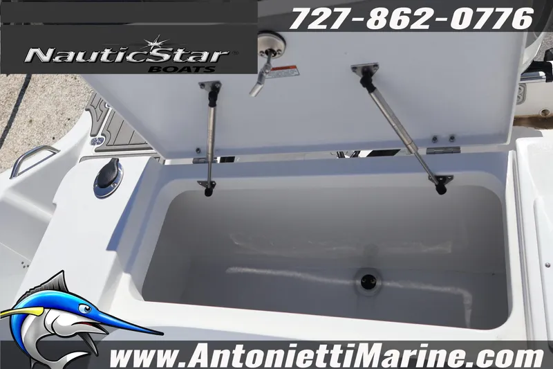 Slide: The Image of Open storage compartment on 2026 NauticStar 292 Legacy boat, featuring hydraulic supports. - 24