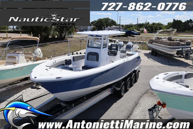 Slide: The Image of 2026 NauticStar 292 Legacy boat on trailer at dealership, surrounded by other boats. - 5