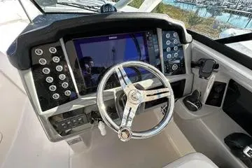 Slide: The Image of 2022 Robalo R317 Dual Console boat dashboard with modern controls and steering wheel. - 7