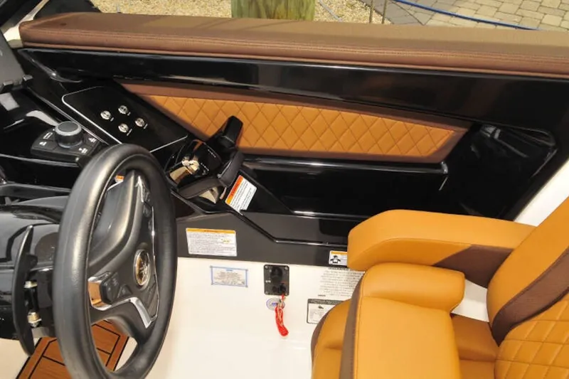 Slide: The Image of 2024 Yamaha Boats 275SDX cockpit with luxurious tan and black interior design. - 17