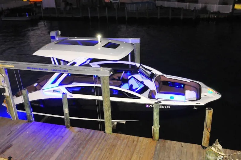 Slide: The Image of 2024 Yamaha Boats 275SDX docked at night with illuminated interior and sleek design. - 2
