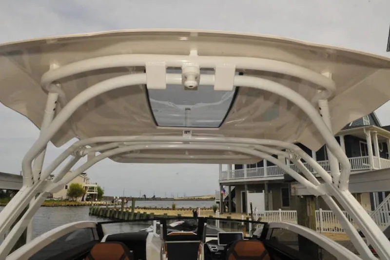 Slide: The Image of 2024 Yamaha Boats 275SDX with sleek canopy design, docked near waterfront homes. - 4