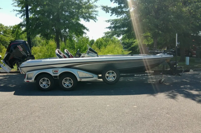 Slide: The Image of 2023 Ranger Z520R boat on trailer, parked outdoors with trees in background. - 3