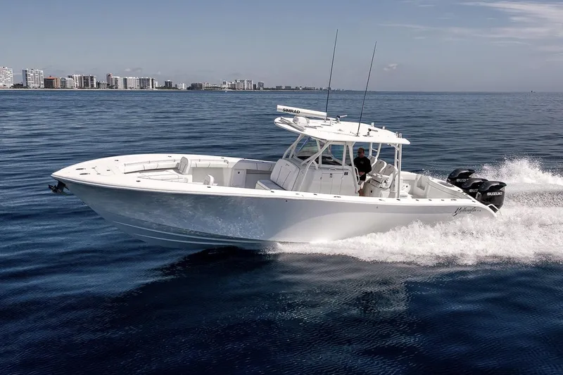 Slide: The Image of 2012 Yellowfin 39 Offshore boat cruising on open water near city skyline. - 12
