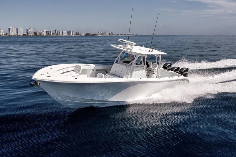 Slide: The Image of 2012 Yellowfin 39 Offshore boat cruising on open water near a city skyline. - 14