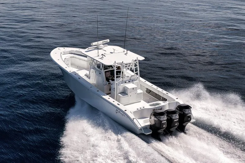 Slide: The Image of 2012 Yellowfin 39 Offshore boat cruising on open water with triple Suzuki engines. - 20
