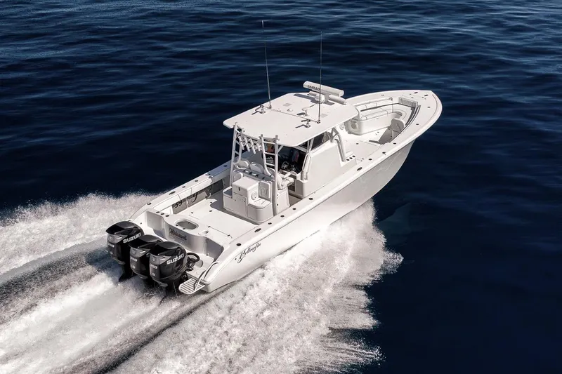 Slide: The Image of 2012 Yellowfin 39 Offshore boat cruising on open water, powered by triple Suzuki engines. - 21