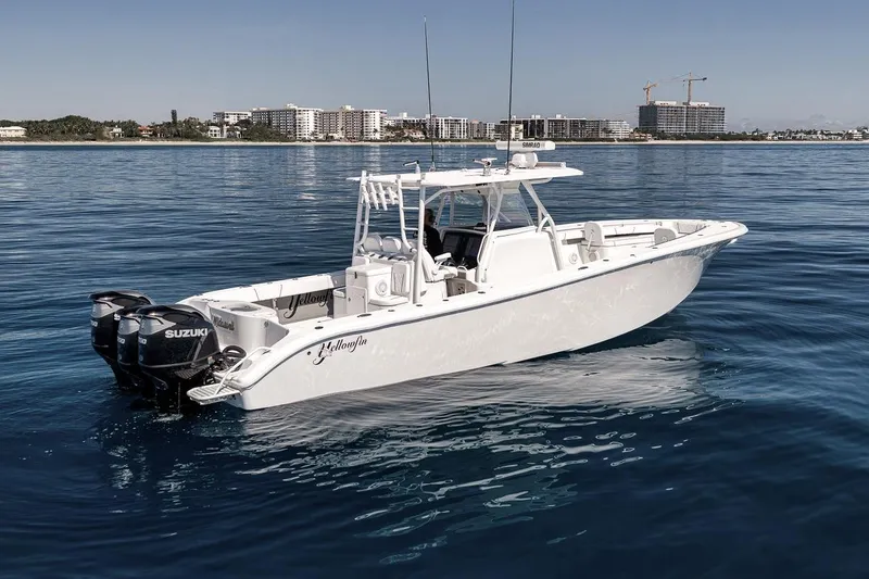 Slide: The Image of 2012 Yellowfin 39 Offshore boat on calm blue water, featuring Suzuki engines. - 4