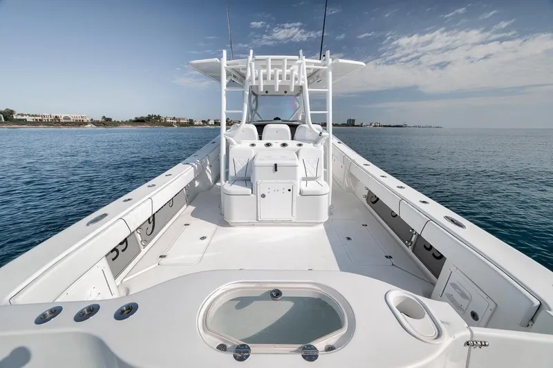 Slide: The Image of 2012 Yellowfin 39 Offshore boat on calm ocean, showcasing spacious deck and sleek design. - 40