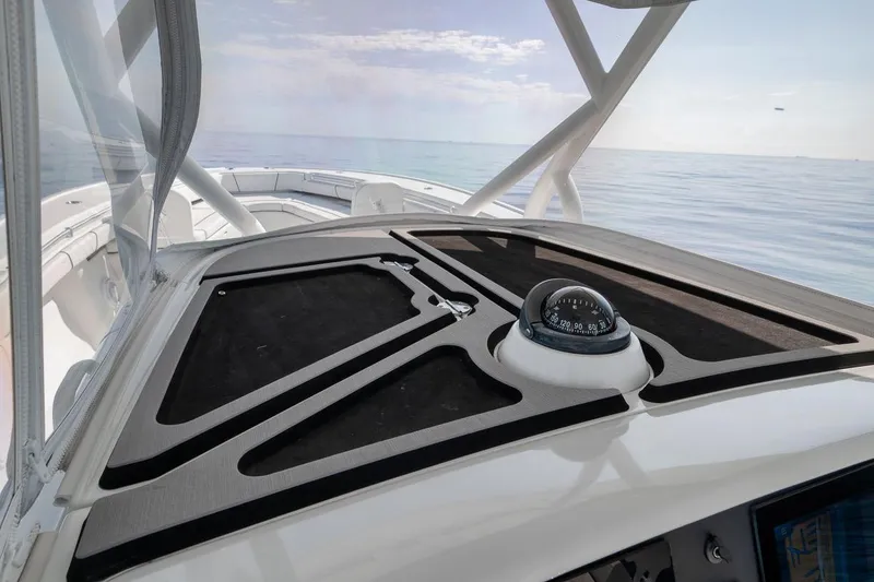 Slide: The Image of 2012 Yellowfin 39 Offshore boat dashboard with compass, ocean view in background. - 54