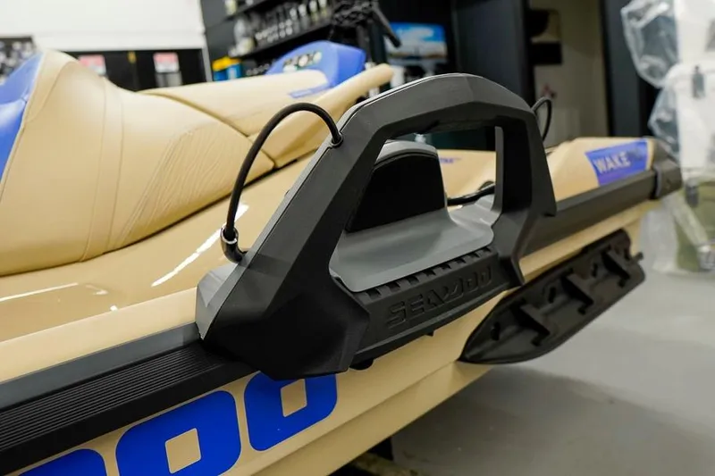 Slide: The Image of 2026 Sea-Doo Wake Pro 230 jet ski with beige and blue seating in showroom. - 14