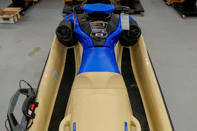 Slide: The Image of 2026 Sea-Doo Wake Pro 230 jet ski, blue and beige, top view in showroom. - 6