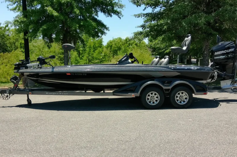 The Image of 2012 Ranger Z520 boat on trailer, parked outdoors with trees in background. - 1