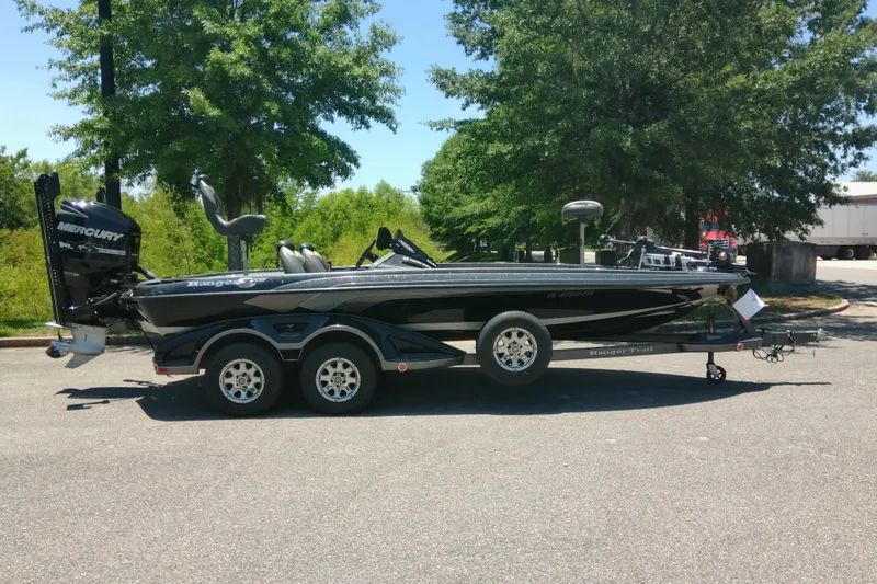 Slide: The Image of 2012 Ranger Z520 boat on trailer, parked outdoors with trees in the background. - 4