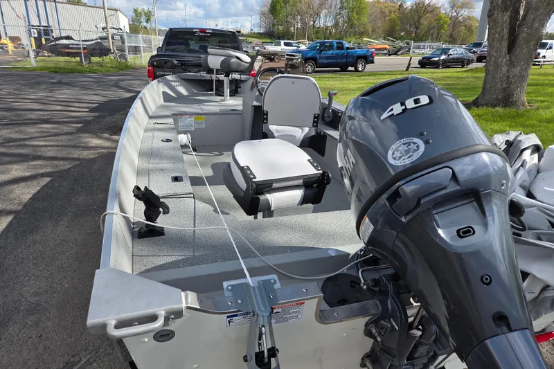 Slide: The Image of 2023 Starcraft Patriot 16 SC boat with 40 HP motor, parked outdoors. - 4