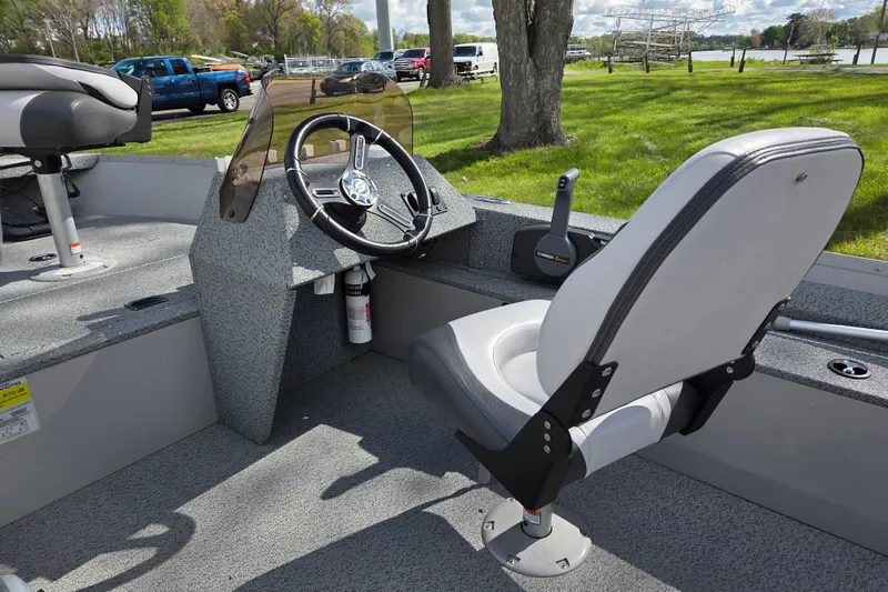 Slide: The Image of 2023 Starcraft Patriot 16 SC boat interior with steering wheel and seating. - 5