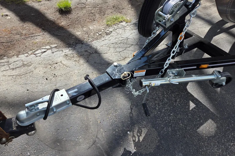 Slide: The Image of Trailer hitch and winch of 2023 Starcraft Patriot 16 SC on asphalt surface. - 9