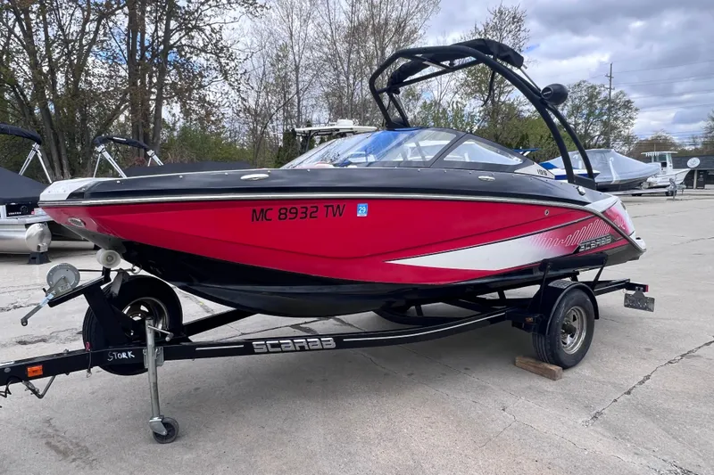 Slide: The Image of 2014 Scarab 195 H.O. speedboat in vibrant red on a trailer, parked outdoors. - 5
