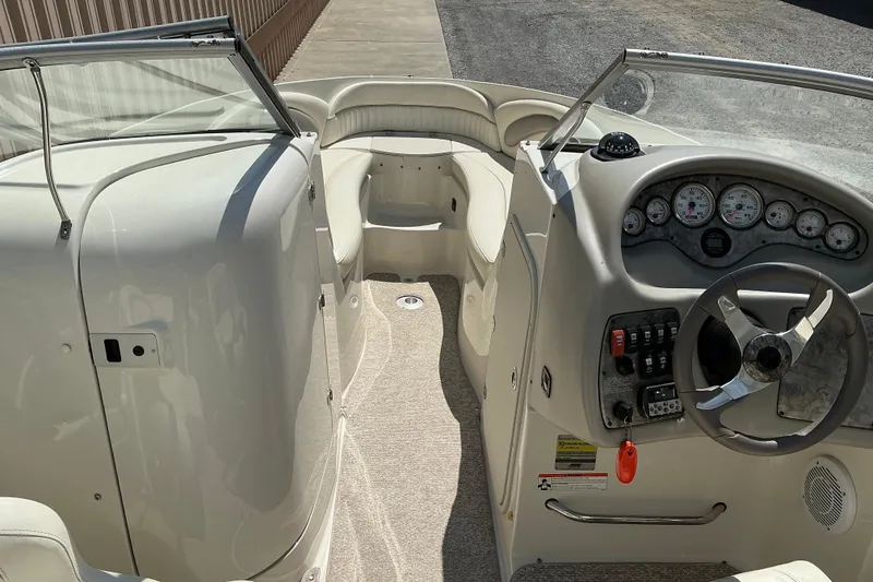 Slide: The Image of 2010 Stingray 250 LR boat interior with steering wheel, dashboard, and seating area. - 10