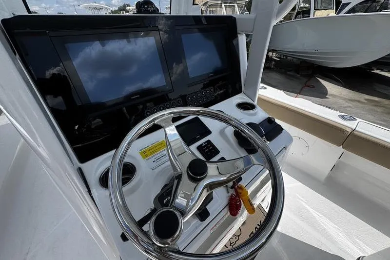Slide: The Image of 2026 Blazer Bay Makaira 2800 boat dashboard with dual screens and steering wheel. - 12