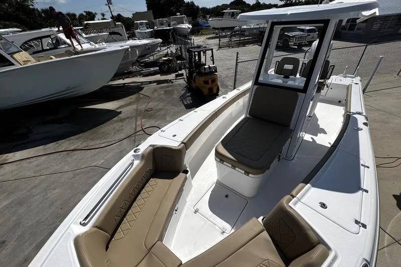 Slide: The Image of 2026 Blazer Bay Makaira 2800 boat with tan seating, docked in a marina. - 13