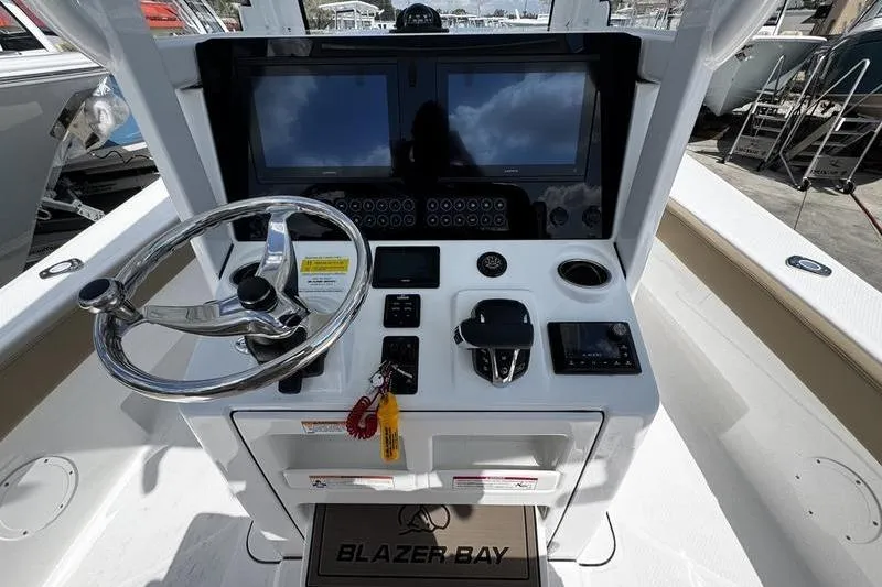 Slide: The Image of 2026 Blazer Bay Makaira 2800 boat console with steering wheel and electronic displays. - 17