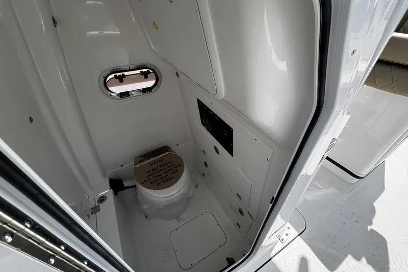 Slide: The Image of 2026 Blazer Bay Makaira 2800 boat interior with compact marine toilet and porthole. - 20
