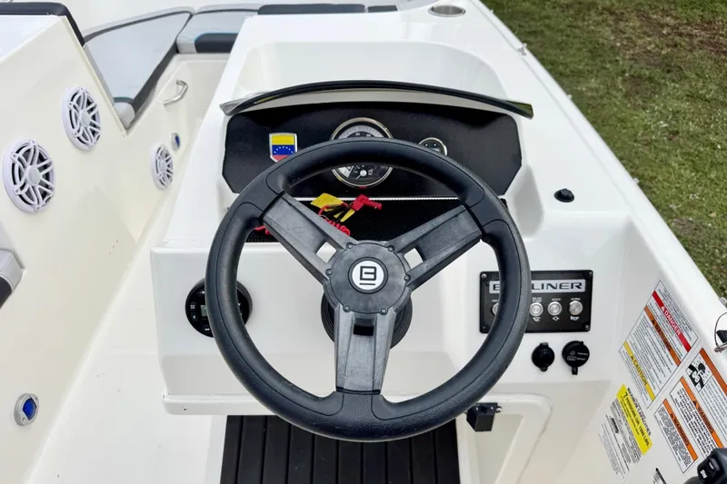 Slide: The Image of 2022 Bayliner Element M17 boat dashboard with steering wheel and control panel. - 13