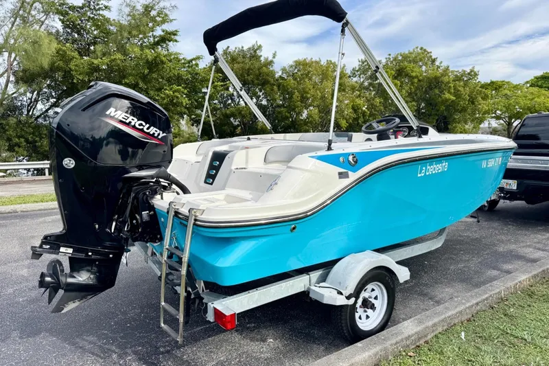 Slide: The Image of 2022 Bayliner Element M17 boat with Mercury engine on trailer, parked outdoors. - 4