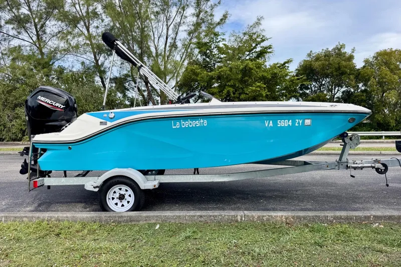 Slide: The Image of 2022 Bayliner Element M17 boat on trailer, vibrant blue color, parked outdoors. - 5