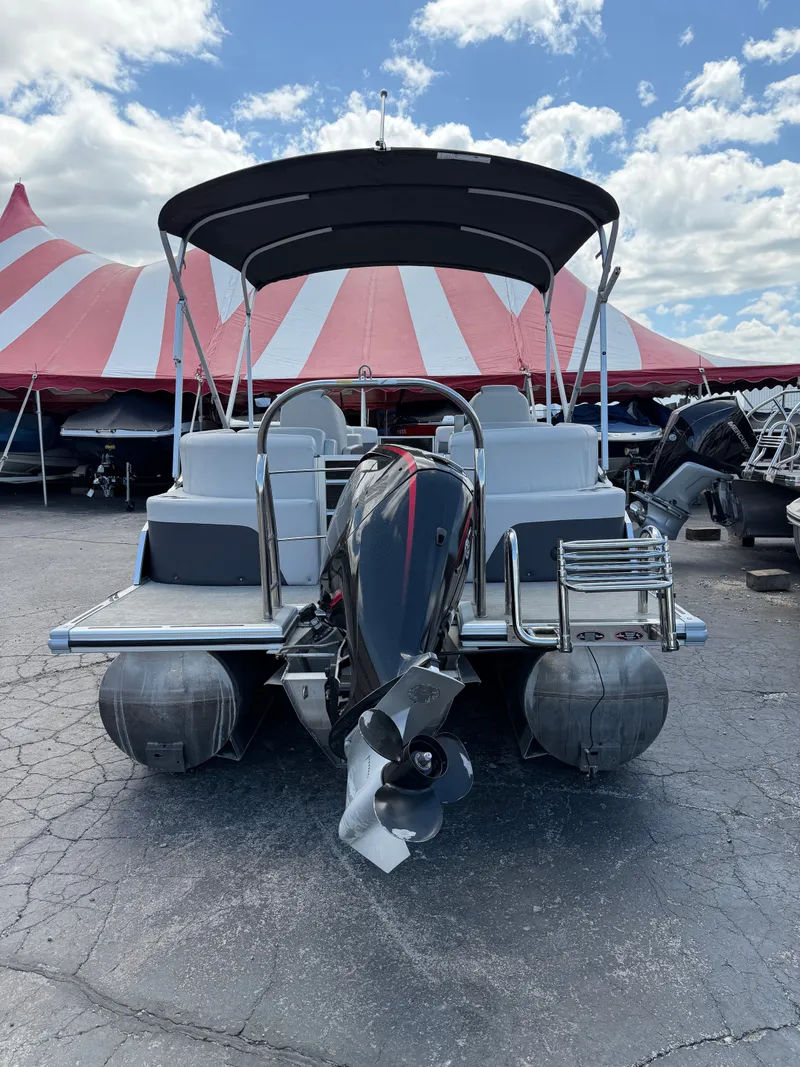 Slide: The Image of 2021 Harris 230 Cruiser CWDH pontoon boat with motor, in front of red and white tent. - 10