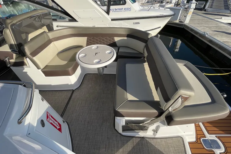 Slide: The Image of 2019 Monterey 295 Sport Yacht interior with cushioned seating and round table. - 13