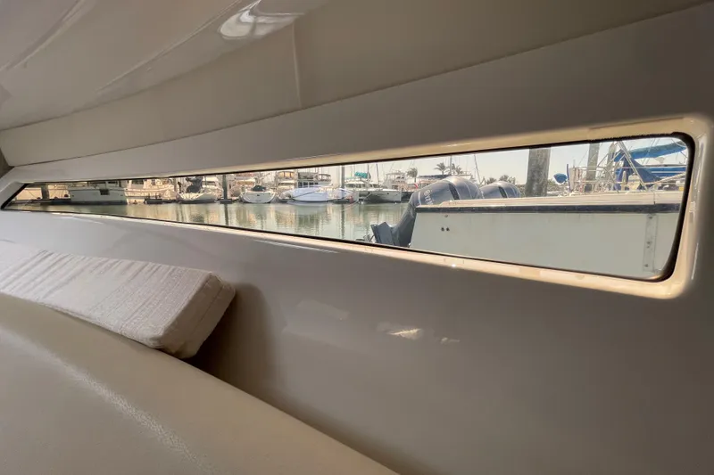 Slide: The Image of Interior view of 2019 Monterey 295 Sport Yacht with marina through window. - 25