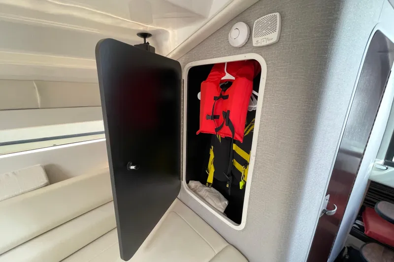 Slide: The Image of Open storage compartment with life jackets inside a 2019 Monterey 295 Sport Yacht. - 27